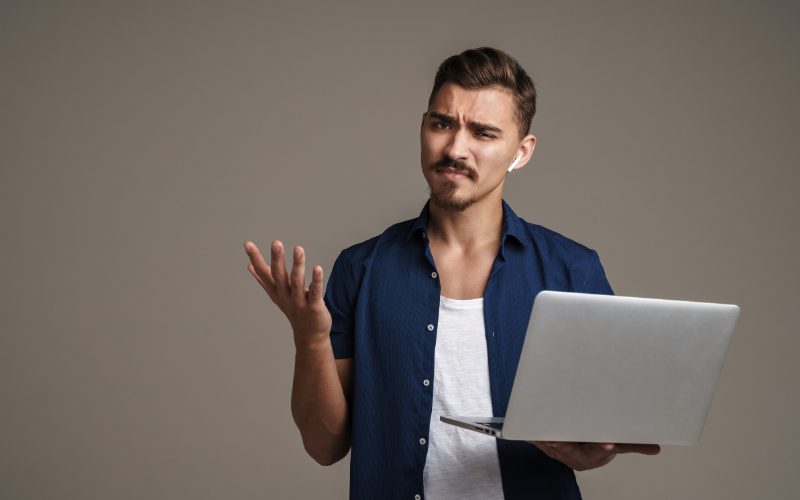 Artificial Intelligence - Man holding a laptop looking confused